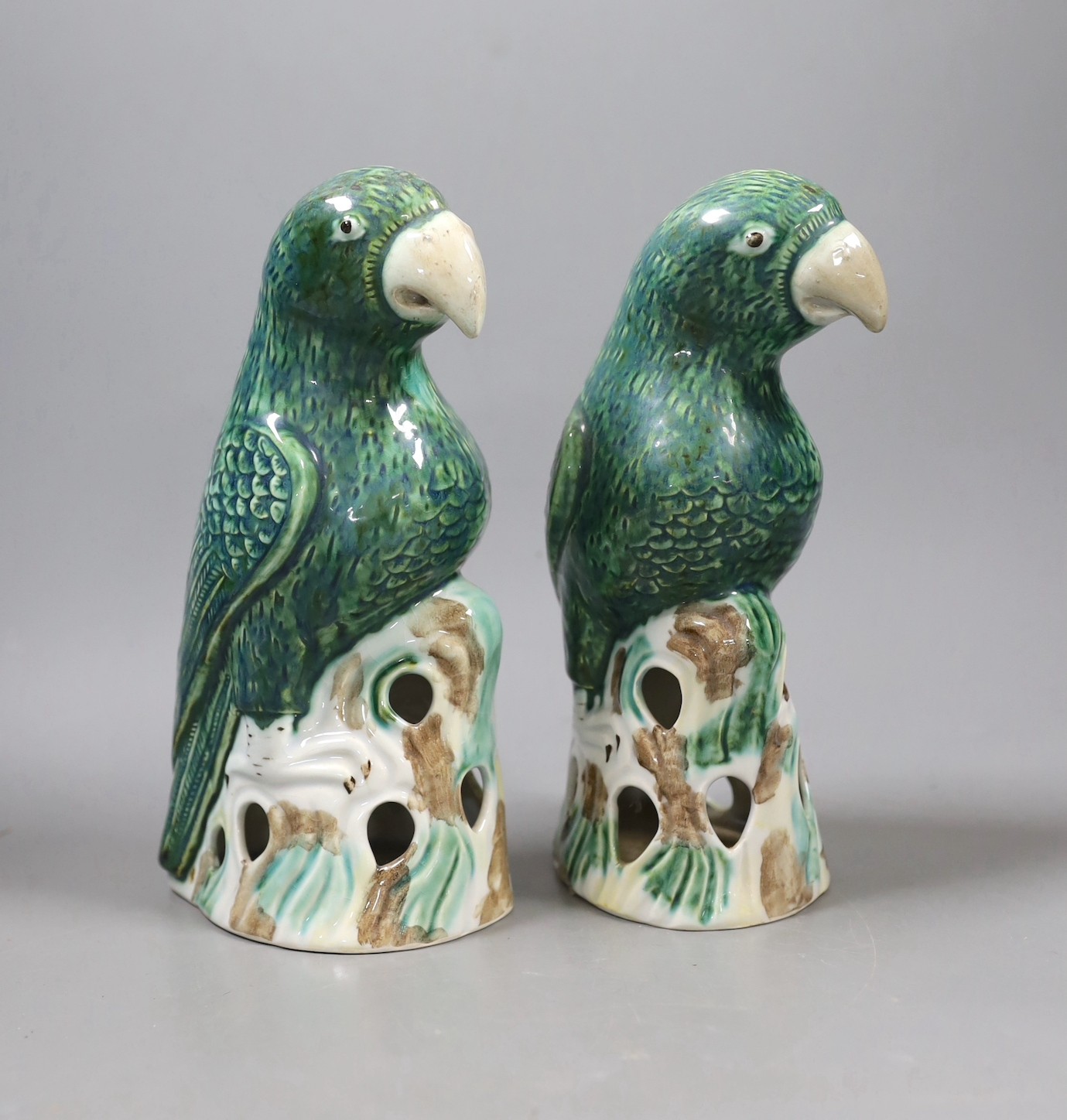 A pair of Asprey marked ceramic parrots on perches made for Recollections Ltd. by Gladstone Pottery Museum. 23cm high